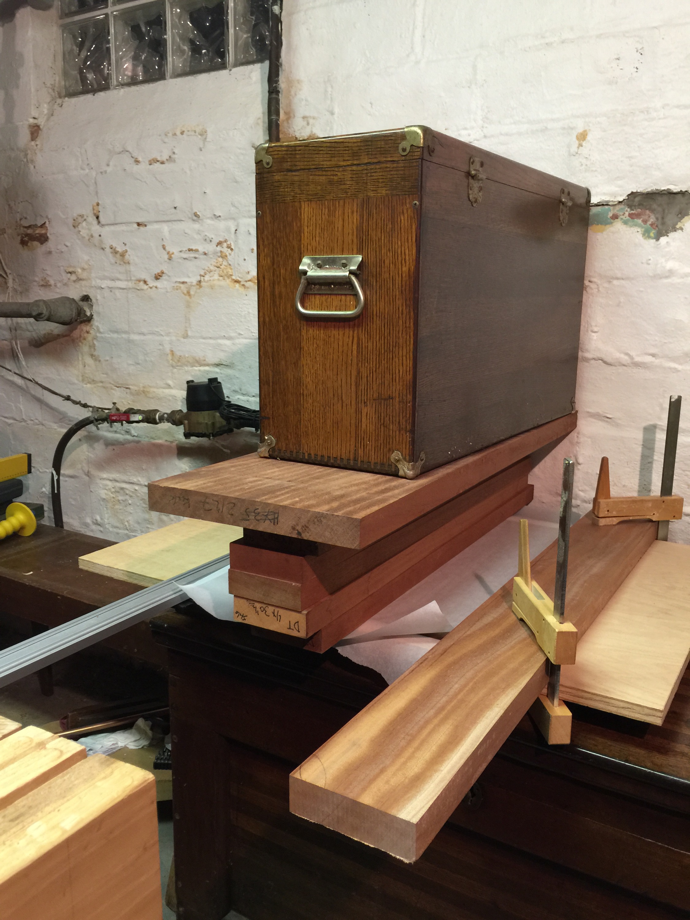 Sophisticated clamping devices (a pile of wood with a toolbox on top), framed nicely by a disgusting basement wall.